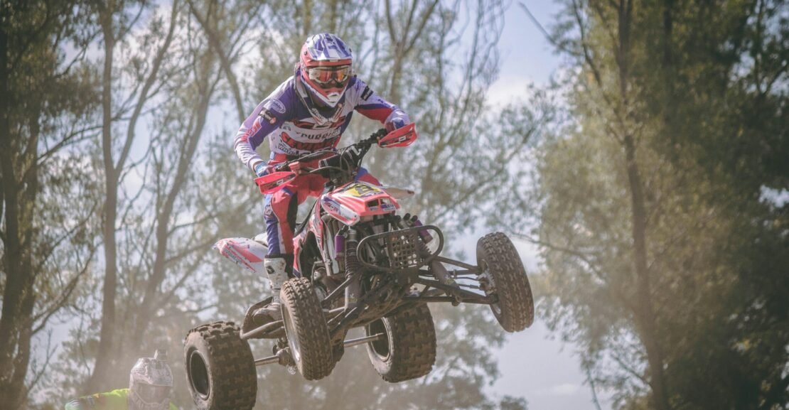 person riding red and black ATV